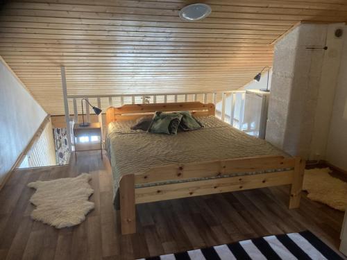 una cama en una habitación con una pared de madera en Hulhavanpuisto B2, Iso-Syöte, Pudasjärvi, en Pudasjärvi