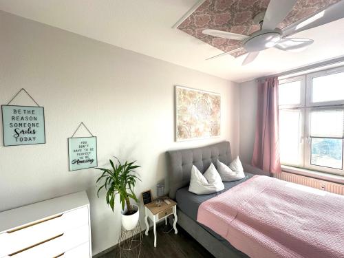 a bedroom with a bed and a ceiling fan at Premium CityApartment *Tiefgarage,Netflix,Zentrum* in Cottbus