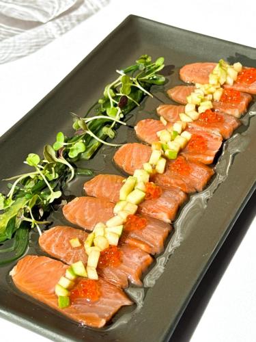 a tray with salmon and vegetables on a plate at Hotel Cal Rei de Talló in Bellver de Cerdanya 
