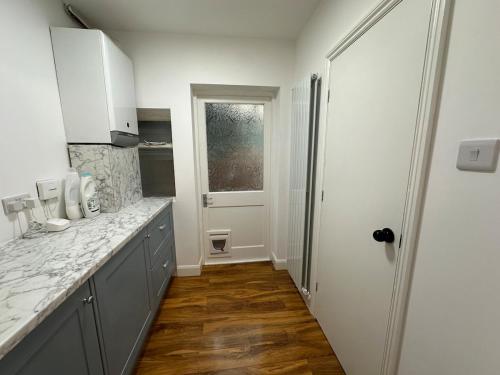 a kitchen with a counter top and a window at Cosy Bungalow Retreat in Grays Thurrock