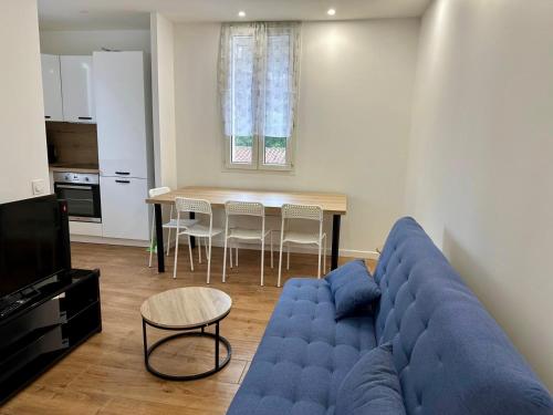 un salon avec un canapé bleu et une table dans l'établissement 2 Bedrooms appartement entièrement rénové Cannes - 200m de la plage, à Cannes
