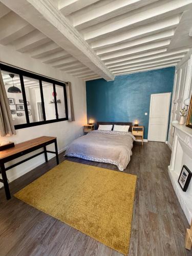 une chambre avec un lit, un bureau et des fenêtres dans l'établissement Cosy getaway in historic Bayeux, à Bayeux