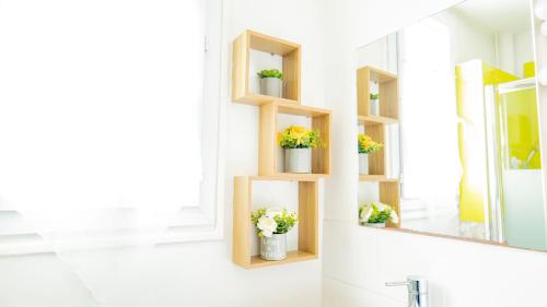 a bathroom with wooden shelves with potted plants at Charming T2 Cozy close to Orly airport in Athis-Mons