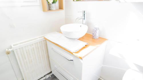 La salle de bains est pourvue d'un lavabo sur un comptoir en bois. dans l'établissement Charming T2 Cozy close to Orly airport, à Athis-Mons