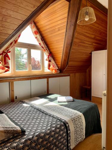 - une chambre avec un lit dans une pièce dotée d'un plafond en bois dans l'établissement La Bussière, à La Bussière