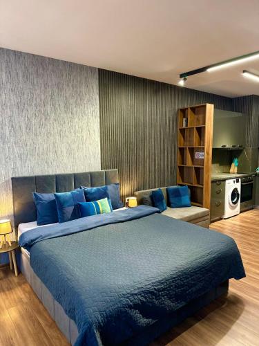 a bedroom with a large bed with blue pillows at West Point Luxury studio in Plovdiv