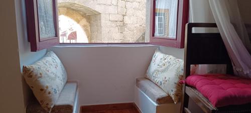 a room with two chairs and two windows at A Casinha do Arco, Porta da Vila in Nisa