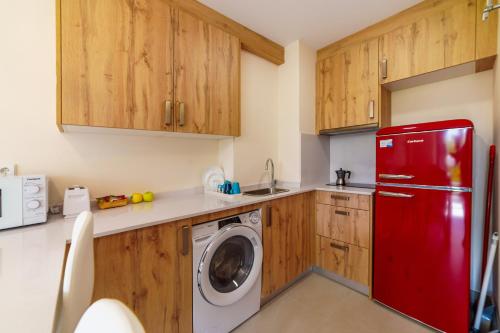 a kitchen with a red refrigerator and a washing machine at ASTURES Viviendas Turísticas in Oviedo