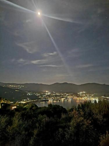 a moonlit view of a city and a body of water at Maison charmante avec vue sur la mer, Olmeto + Cheminée in Olmeto