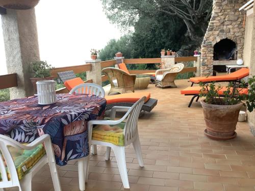 a table and chairs sitting on a patio at Maison charmante avec vue sur la mer, Olmeto + Cheminée in Olmeto