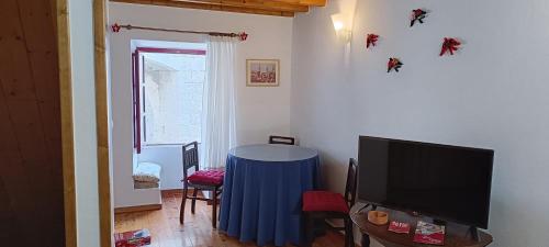 a living room with a table and a tv at A Casinha do Arco, Porta da Vila in Nisa