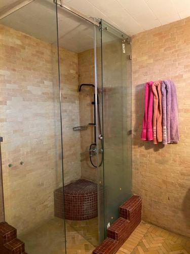 a glass shower with pink towels hanging on a wall at dar hassbia in Fez