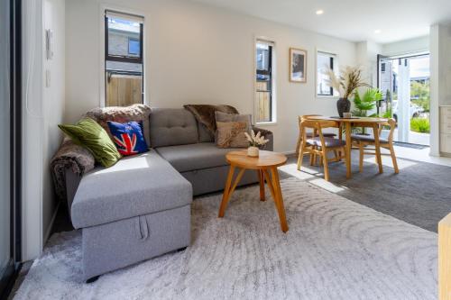 a living room with a couch and a table at Escape at the park: 1 bed 1 bath w/carpark in Christchurch