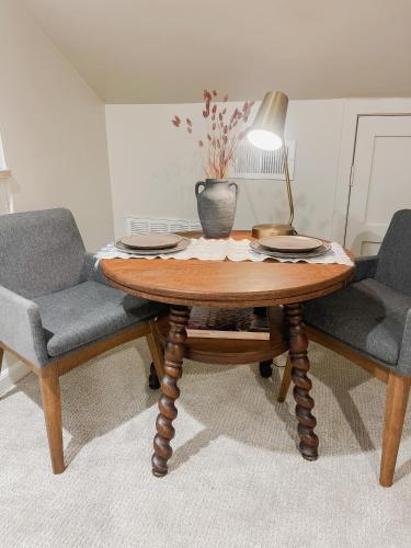 a wooden table with two chairs and a lamp at Guesthouse on Girod in Mandeville