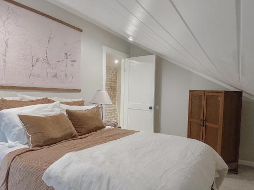 a bedroom with a large bed with white sheets at Guesthouse on Girod in Mandeville