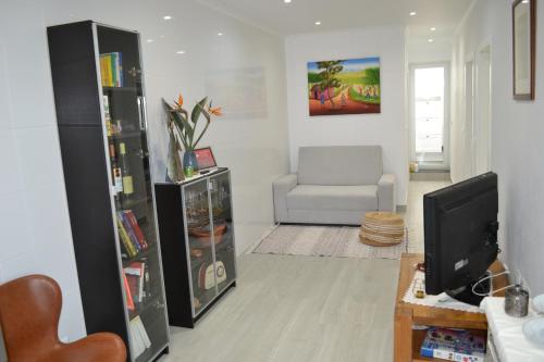 a living room with a television and a chair at Casa do Frade in Abrantes