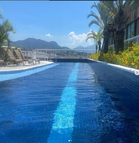 a swimming pool with blue water in a resort at Lapa Loft, estúdio vintage com total infraestrutura na Lapa, RJ in Rio de Janeiro
