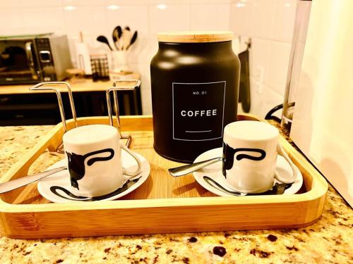 a tray with two cups and a jar of coffee at Lapa Loft, estúdio vintage com total infraestrutura na Lapa, RJ in Rio de Janeiro