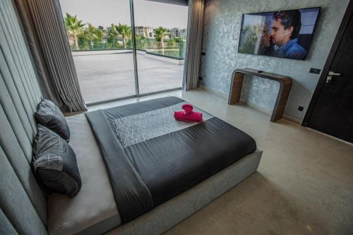a bedroom with a bed with a pink item on it at villa éden marrakech in Oulad Ikhia