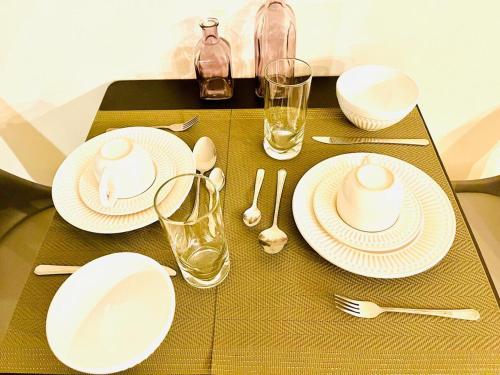 a table with white plates and silverware on it at Lapa Loft, estúdio vintage com total infraestrutura na Lapa, RJ in Rio de Janeiro