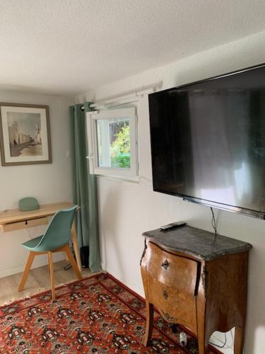 un salon avec une grande télévision à écran plat au mur dans l'établissement Les Rives de CAUPIAN, à Saint-Médard-en-Jalles