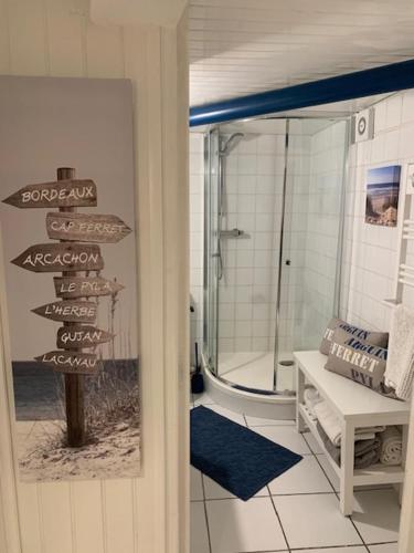 a bathroom with a shower and signs on the door at Les Rives de CAUPIAN in Saint-Médard-en-Jalles