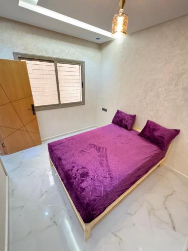 a large purple bed in a room with a window at Fes shore listings in Fès