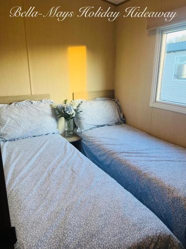 two beds sitting next to each other in a room at Bella-Mays Holiday Hideaway in Lincolnshire