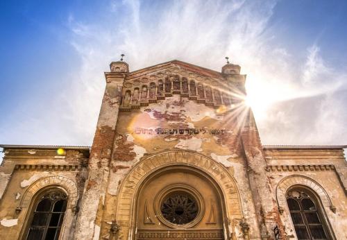 an old building with the sun shining on it at Apartmány Bytča in Bytča