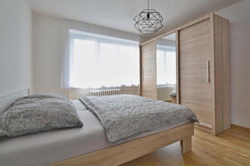 a bedroom with a large bed and a large window at Apartmány Bytča in Bytča