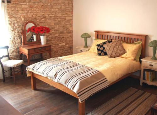 1 dormitorio con cama y mesa con espejo en La Greletterie en Champagné-le-Sec