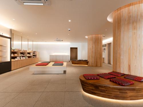 a living room with two beds and a table at Hotel Tenpyo Naramachi in Nara