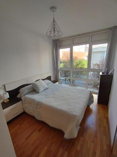 a bedroom with a bed and a large window at Hollyfoz Arenal in Foz