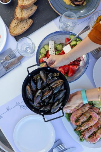 a table with a pan of mussels and a bowl of food at Lido Hotel in Xylokastron