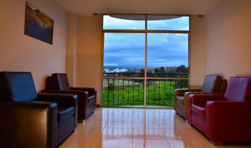 a waiting room with chairs and a large window at Hotel San Marcos in Paipa