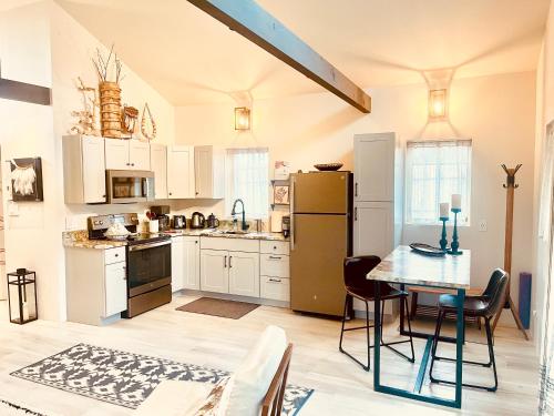 eine Küche mit Tisch und Kühlschrank in der Unterkunft Santa Fe Modern FARMHOUSE 1 ACRE PRIVATE RD SOAKING ROOM 3 min Canyon rd in Santa Fe