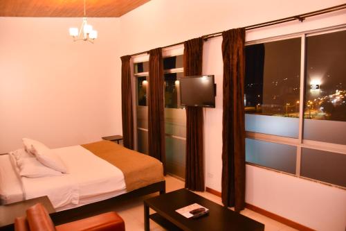 a hotel room with a bed and a large window at Hotel San Marcos in Paipa