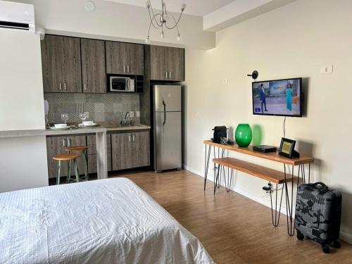 een slaapkamer met een bed en een keuken met een koelkast bij Define Pinheiros 34 in Sao Paulo