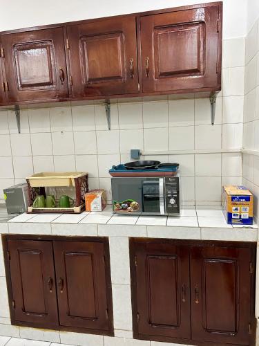 a kitchen counter with a microwave on top of it at Omysweethome in Pointe-Noire