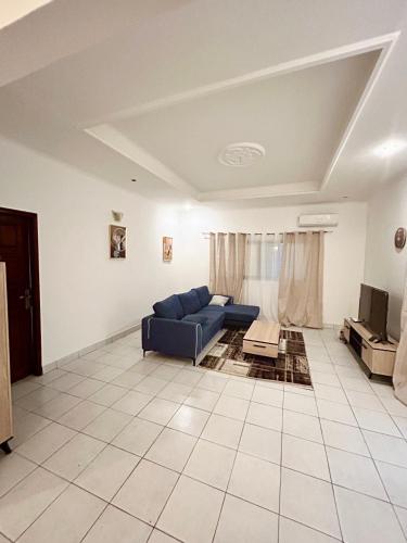 a living room with a blue couch and a tv at Omysweethome in Pointe-Noire