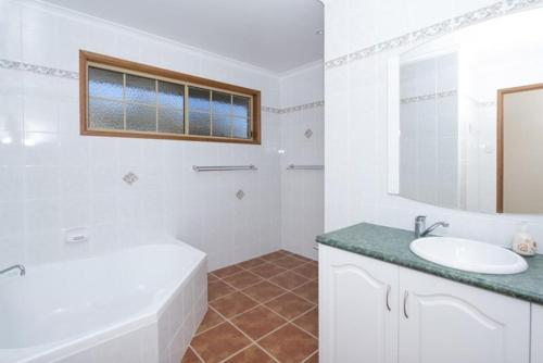 a white bathroom with a tub and a sink at Severnview in Ballandean