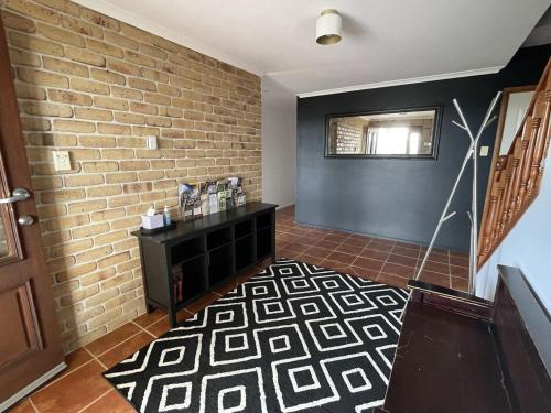 a room with a brick wall and a black table at Severnview in Ballandean