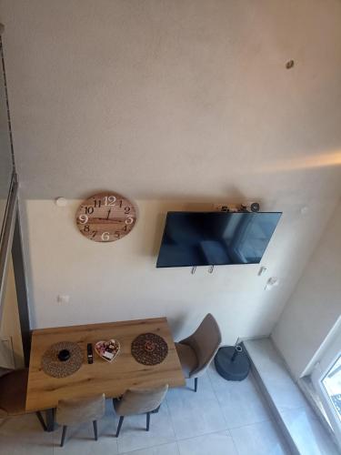 a room with a table and a clock on the wall at Bakery apartments in Perea