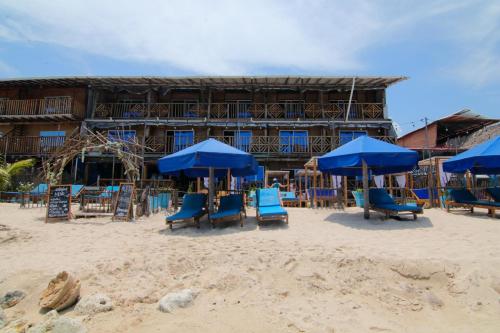 a group of blue chairs and umbrellas on a beach at Cabaña Coral Azul in Playa Blanca
