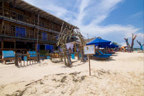 a beach with blue umbrellas and a playground at Cabaña Coral Azul in Playa Blanca