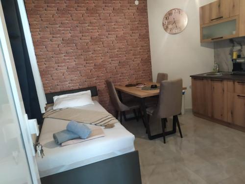 a room with a bed and a table and a brick wall at Bakery apartments in Perea