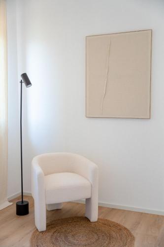 a white chair in a room with a lamp at La casa di Ernino in Tortoreto Lido