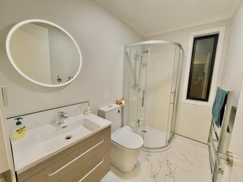 a bathroom with a sink and a shower and a toilet at Lifestyle with Tennis Court in Tamahere