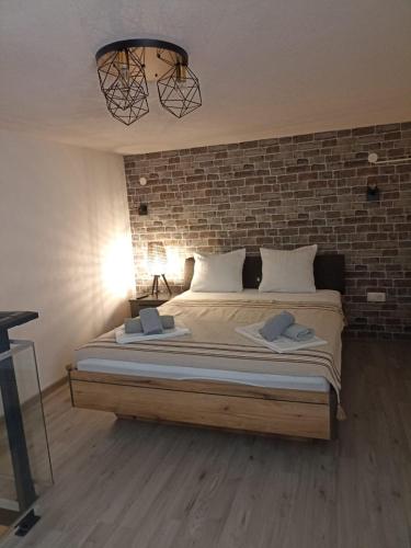 a bedroom with a large bed with a brick wall at Bakery apartments in Perea