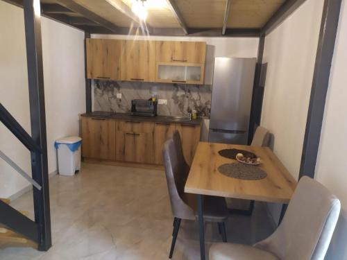 a kitchen with a wooden table and a refrigerator at Bakery apartments in Perea